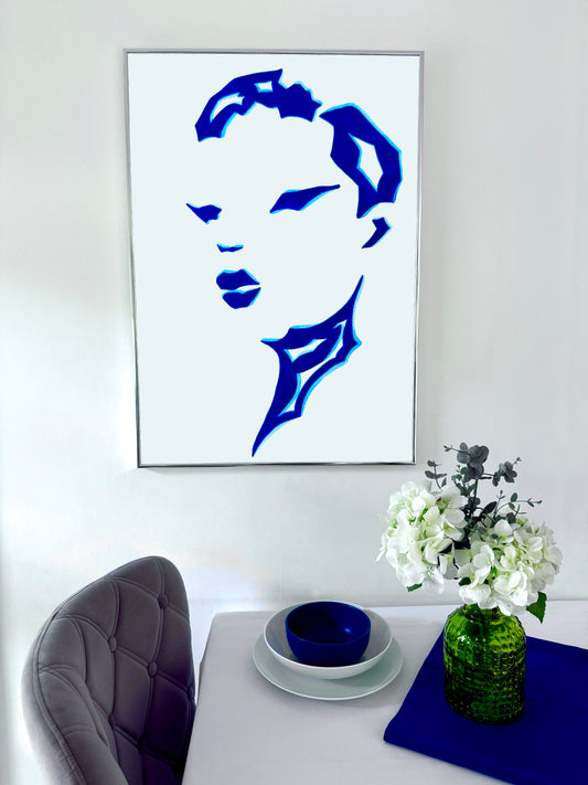Framed blue and white portrait on a wall above a table with decorative items.