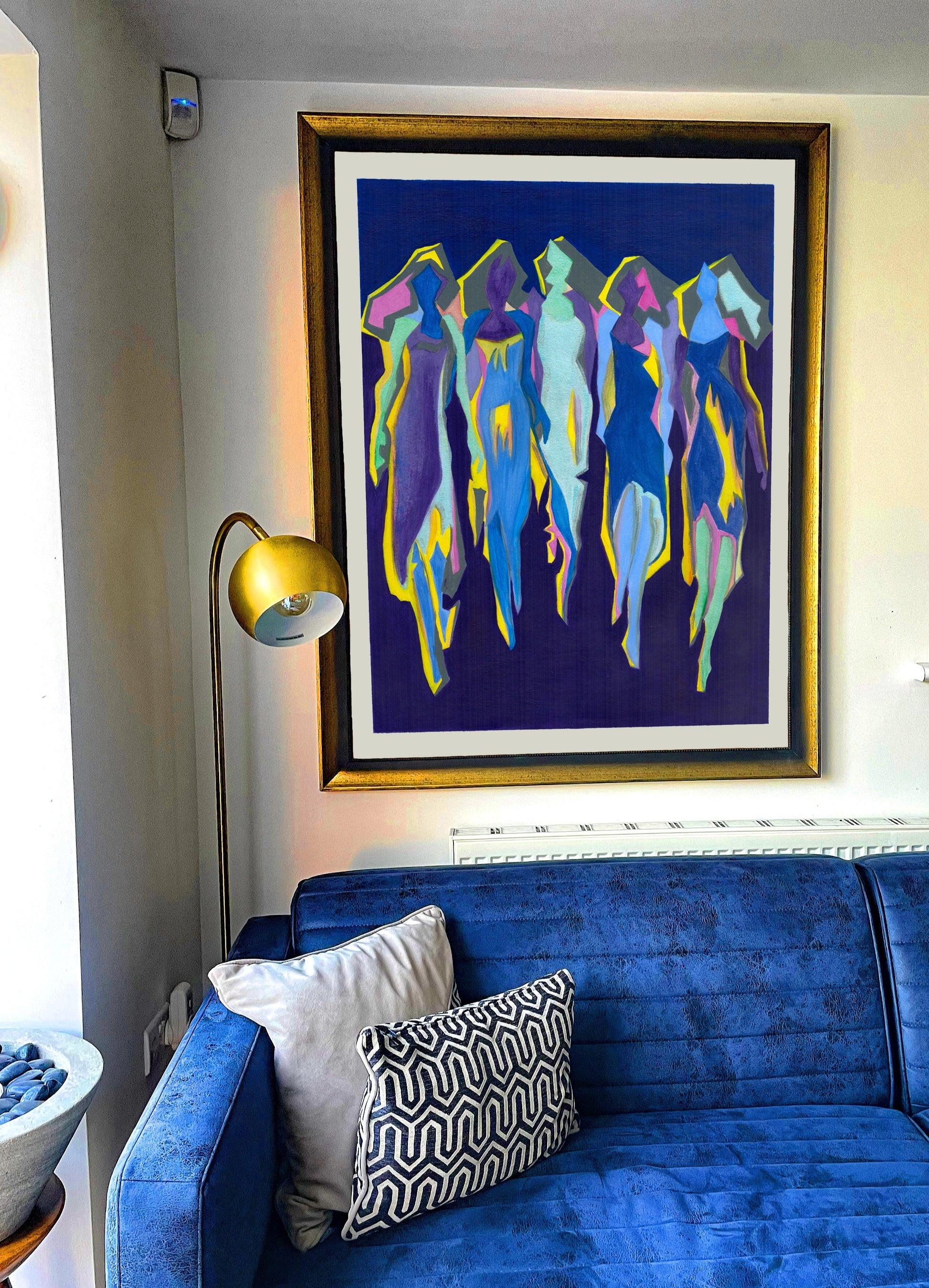 Blue sofa with decorative pillows in a room with a colorful abstract painting on the wall.