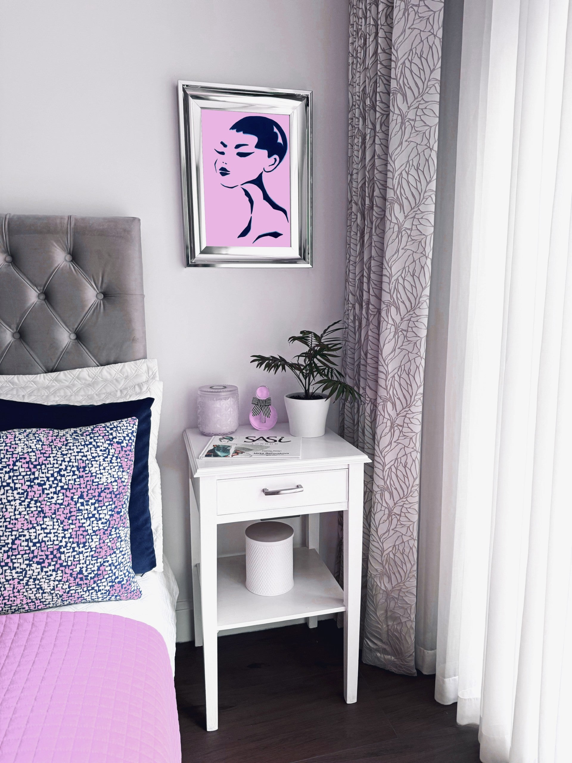 Bedroom with a bed, nightstand, and wall art of a portrait of an Asian woman.